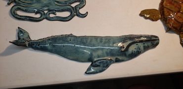 Grey Whale, high fired wall hanging approximately 27 inches long and 8 inches wide.