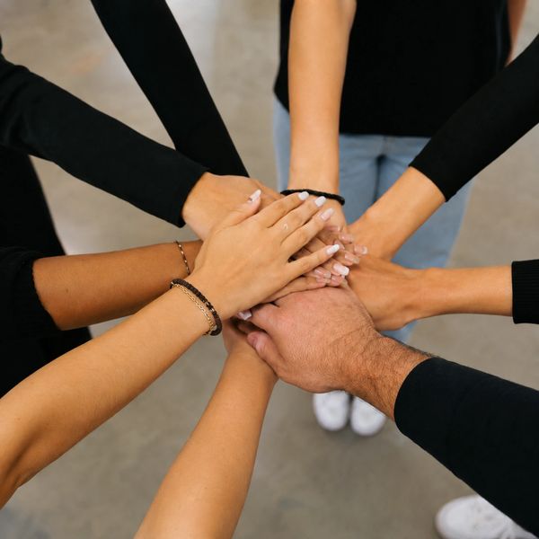 Group hands stacked in unity.