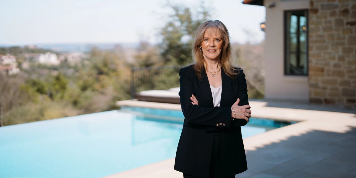 Woman standing confidently by a pool.