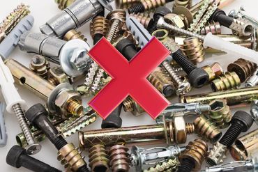 A large red X over a pile of assorted screws, bolts, and wall anchors.