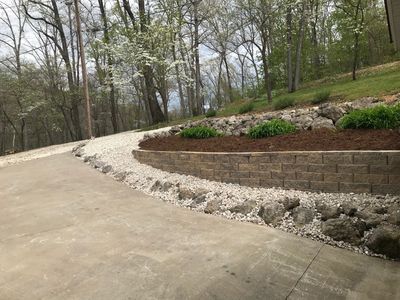 Terraced property with retainer wall, rock terrace, aggregate and driveway to keep all soil.