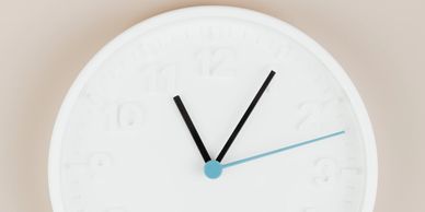 Minimalist white wall clock showing time at 11:05:11.
