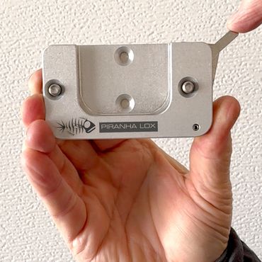 hand holding a Piranha Lox mount with extended lever