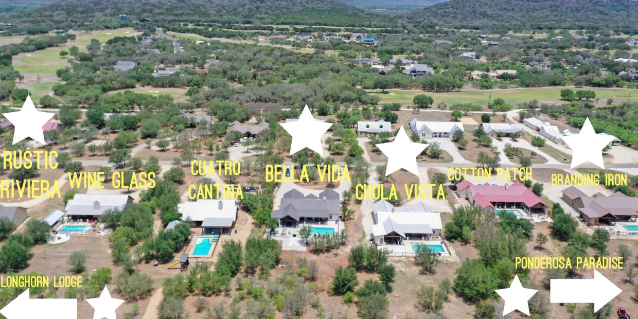 Aerial view of labeled homes in a rural community with green trees and hills.