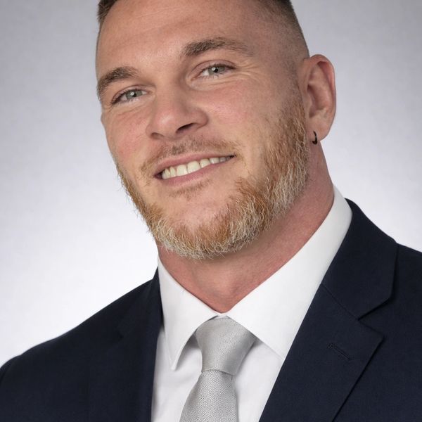 Smiling man in suit and tie.