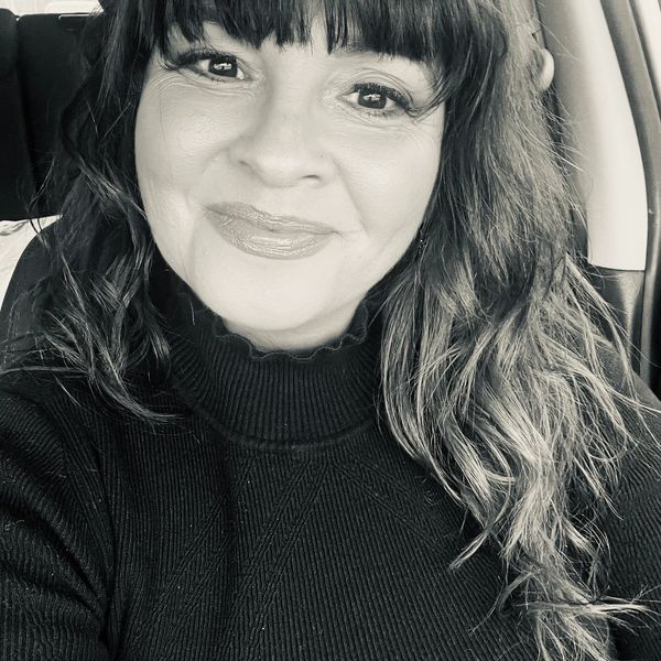 Smiling woman with bangs in a car.