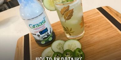 Cucumber lime drink with fresh slices on a wooden board.