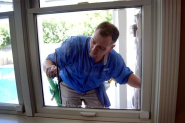 Man uses squeegee to clean a window