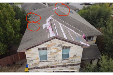 A house roof with red circles highlighting multiple vent pipes and roof patches.