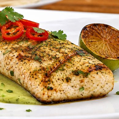 Grilled mahi-mahi on a square white plate with spicy avocado salsa.