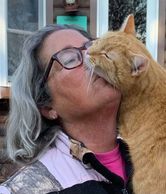 A woman kissing a cat.