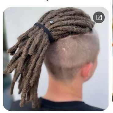 Person with dreadlocks tied back and shaved sides.