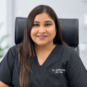 Smiling female doctor in black scrubs.