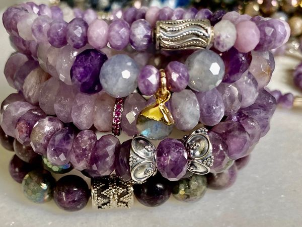 Purple gemstone bracelets on a marble table