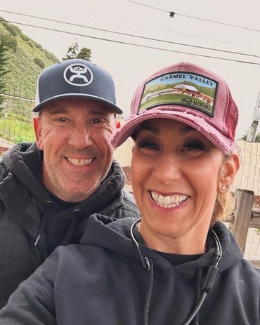 Smiling couple outdoors wearing casual hats and hoodies.