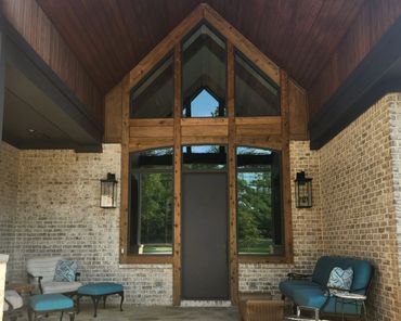 Cozy outdoor seating area with blue cushions and wooden accents on brick wall.