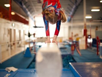 Girl doing a handstand on the beam