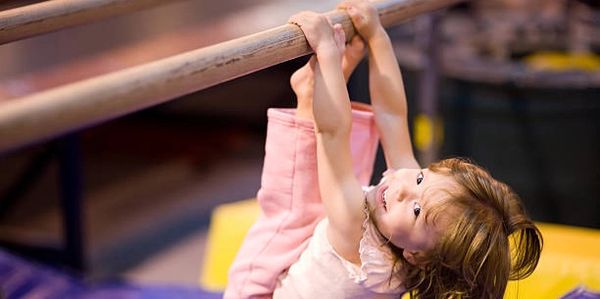 Little girl hanging from the bar