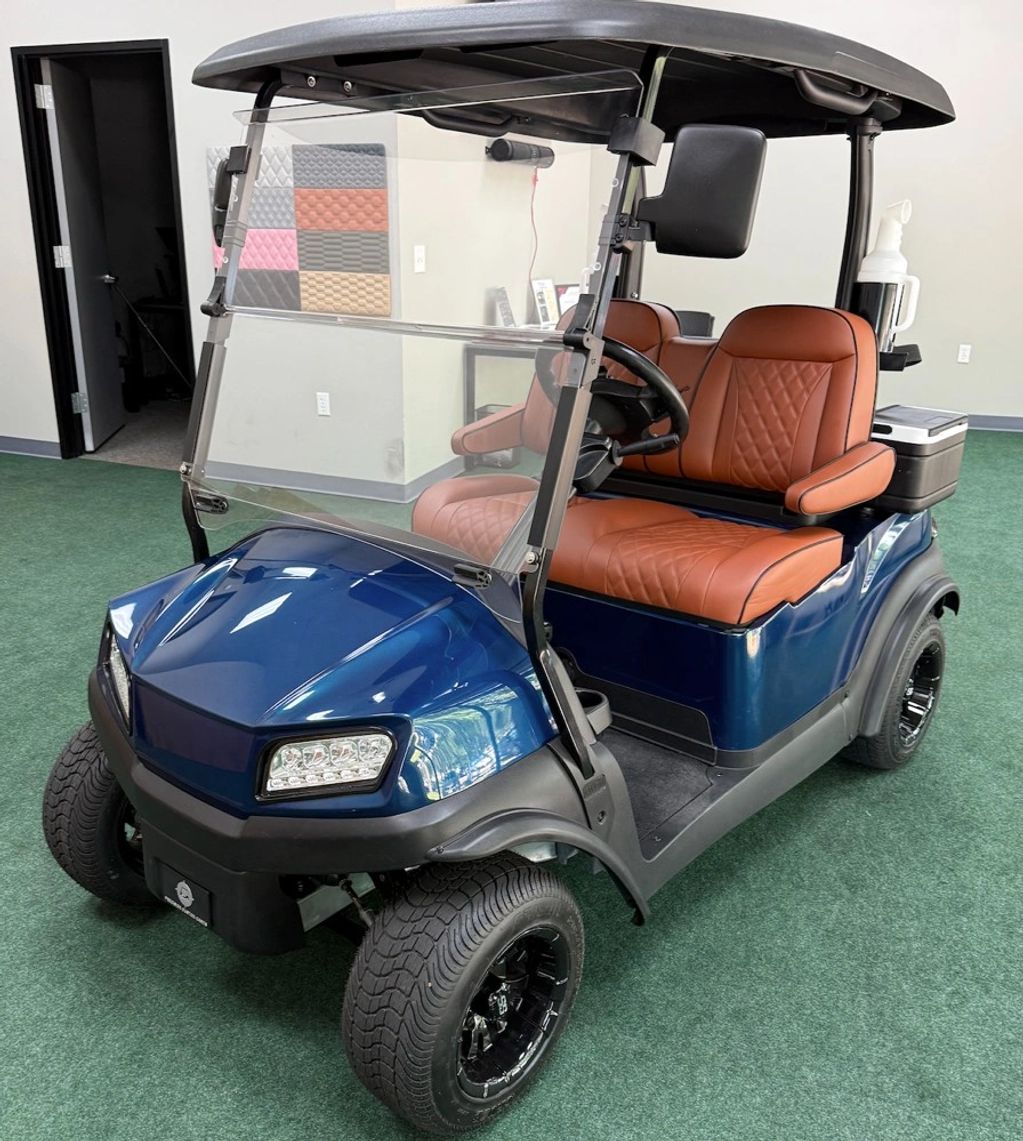 Blue golf cart with brown leather seats indoors.