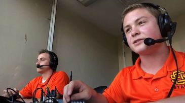 Two young announcers with headsets in an indoor booth.