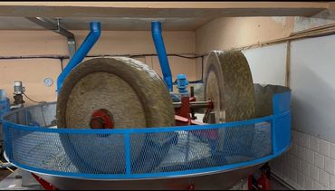 Large stone grinding wheels in an industrial setting.