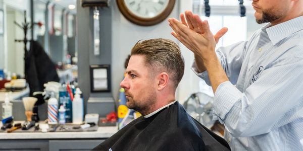 barber rubbing gel into hands to style a client's hair