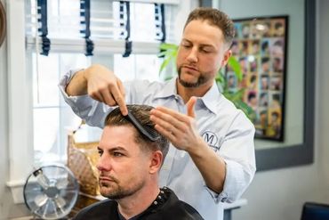 Matt running a comb through a client's hair