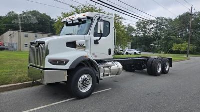 White heavy-duty truck chassis parked on the street.