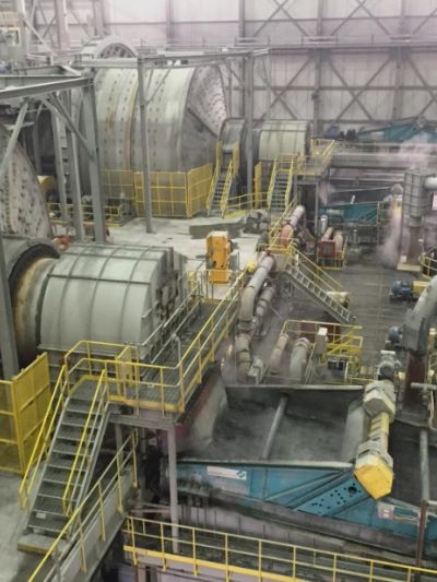 Industrial factory interior with machinery and yellow railings.