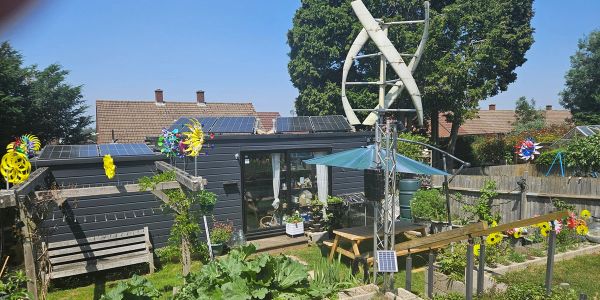 A solar-powered garden with wind turbines and colorful decorations in a sunny backyard.