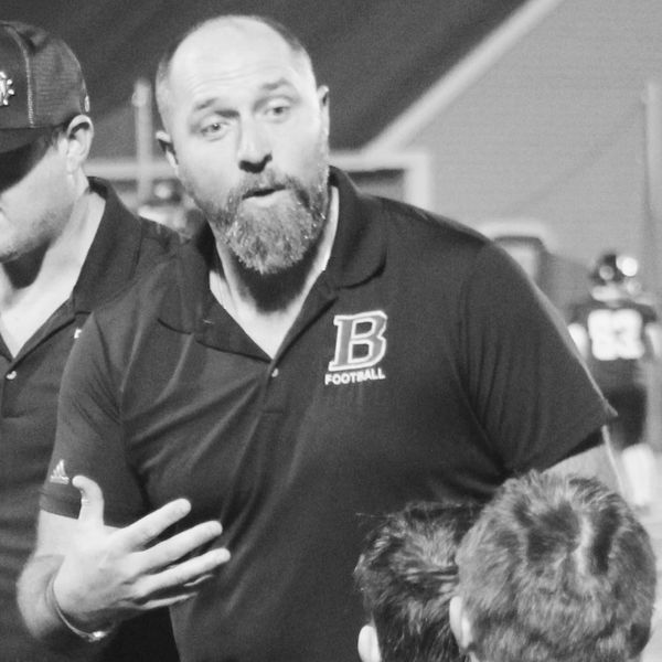 Our Head Coach, Kacey, discussing halftime adjustments with his youth tackle football team.