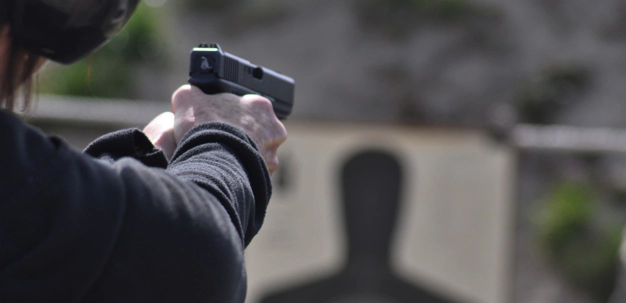 Hands on pistol aimed at target