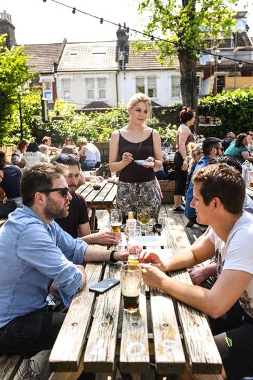 People enjoying a drink in the sunny beer garden at the Selkirk, Tooting, South London.