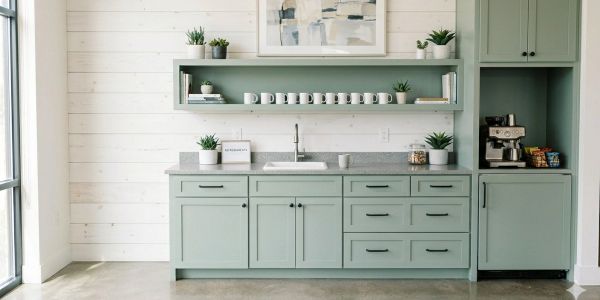 Modern kitchen with sage green cabinets and a minimalist design.