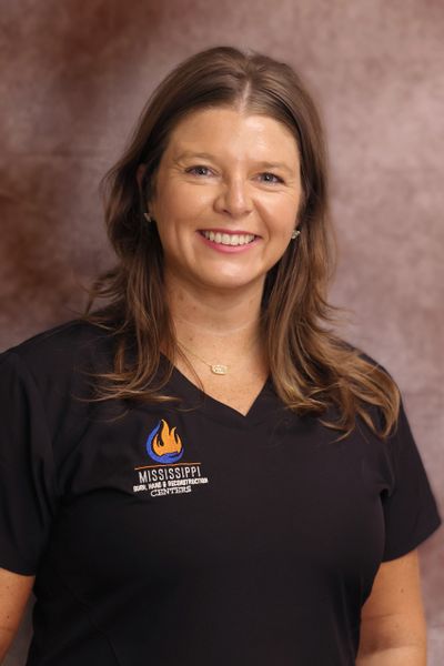 Smiling woman in a black Mississippi Gulf Coast shirt.