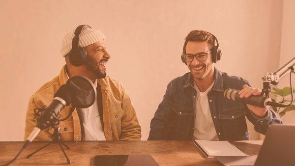 dos personas sonriendo en una sala de grabación 