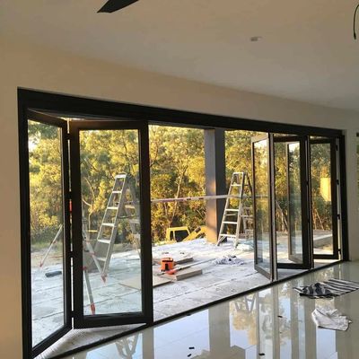 Large folding glass doors opening to an outdoor area with ladders and tools.