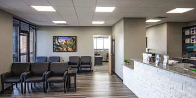 Modern medical office waiting room with chairs and reception desk.