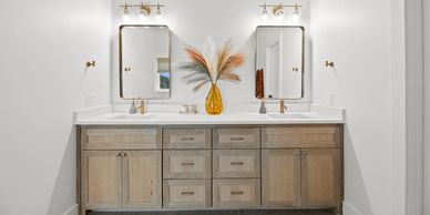 Modern double vanity bathroom with wooden cabinets and dual mirrors.