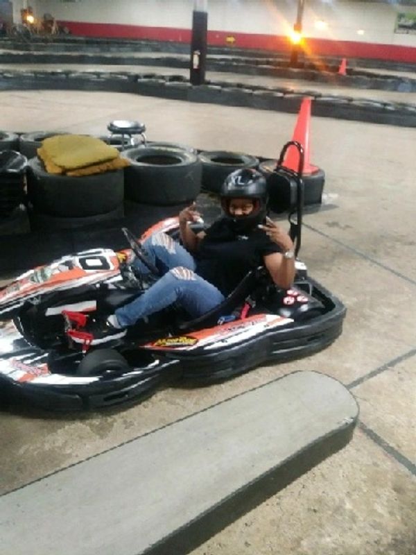 A cool lady gears up for high-speed thrills on a go-karting date night, determined to beat her man!