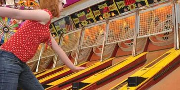 Girl playing skee ball at Extreme Go-Kart Racing in Clio, Michigan—she's gearing up to win prizes.