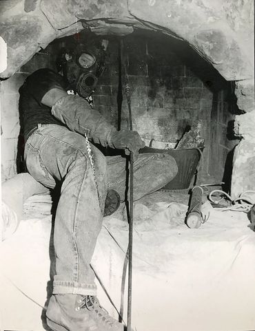 Chimney sweep inside a masonry firebox performing a chimney inspection and sweep