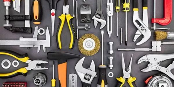 Various hand tools neatly arranged on a dark surface.
