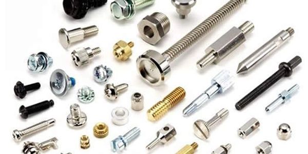 Various metal screws, bolts, and fasteners arranged on a white surface.