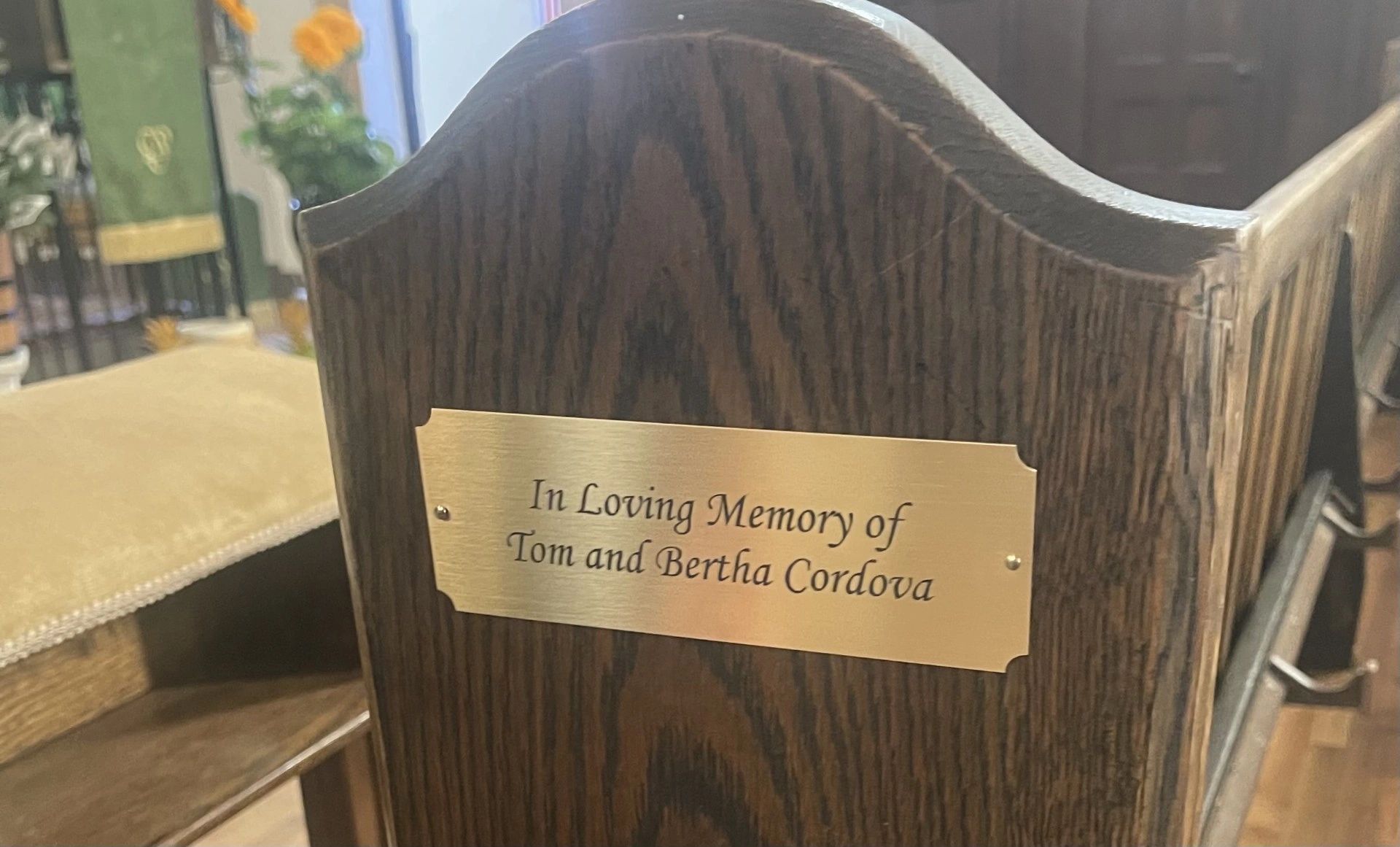 A wooden bench memorial plaque for Tom and Bertha Cordova.