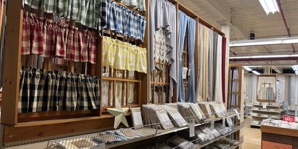 Curtains and fabric samples displayed in a cozy store aisle.