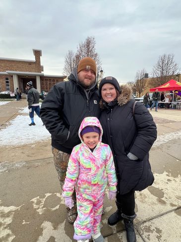 Family dressed warmly on a cold day outdoors.