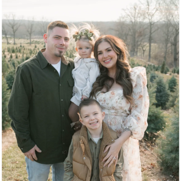 Happy family posing outdoors among trees.