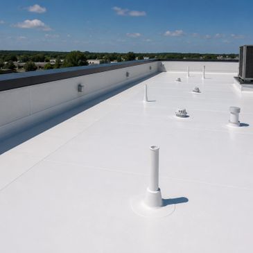 Clean white flat roof with pipes and vents under blue sky.