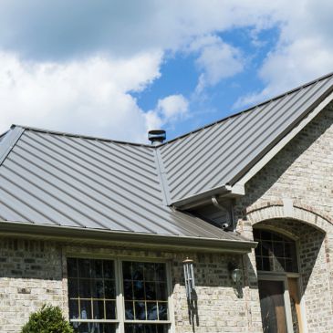 House with a metal roof under blue sky.